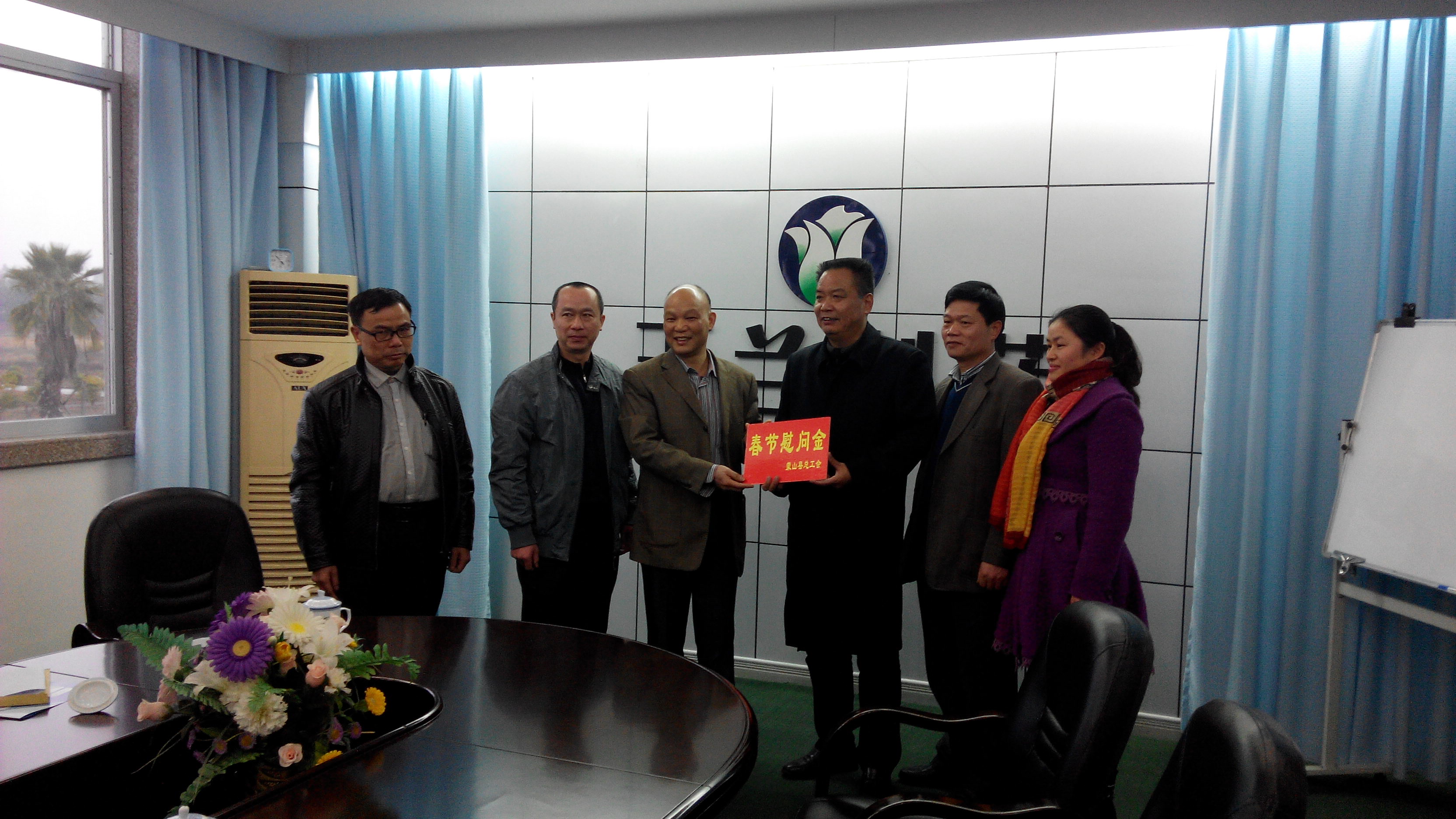 1月28日，梧州市總工會副主席謝海益帶隊到蒙山開展春節(jié)前慰問活動。圖為市總工會謝副主席給玉蘭制藥公司送上春節(jié)慰問金。--